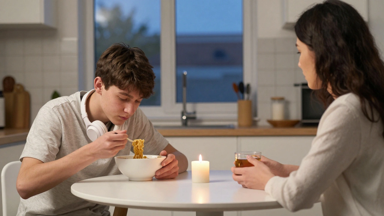 A teenager and parent sit across from each other at a kitchen table, eating different meals, sharing silent presence.