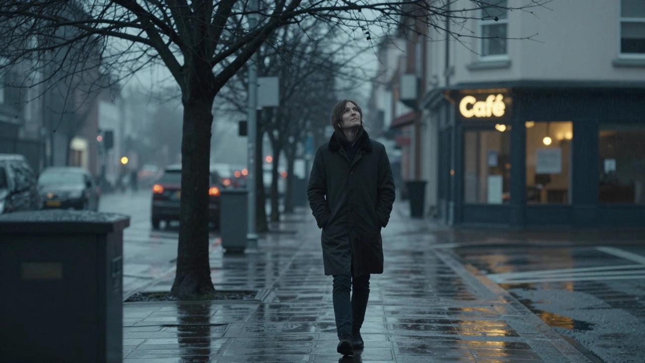 A person walking alone in the rain, no phone or headphones, looking up at the gray sky.